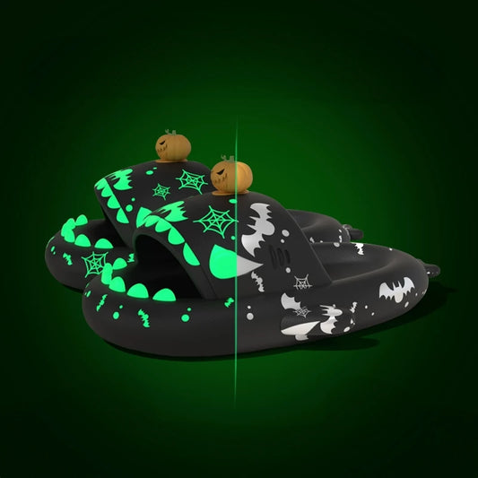 Black Cloudsharks Halloween shark slides with glowing green spiderwebs, bats, teeth, and 3D pumpkin toppers showing day and night glow effects. Black Halloween Shark Slides featuring a 3D jack-o'-lantern pumpkin charm topper, bat and spiderweb prints, and glow-in-the-dark teeth and accents shown in a split-screen daytime/nighttime comparison.