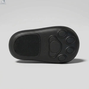 Bottom view of a black Cloudsharks cat slipper showing the anti-slip paw pad tread pattern, textured grip, and size markings on a clean seamless studio background.