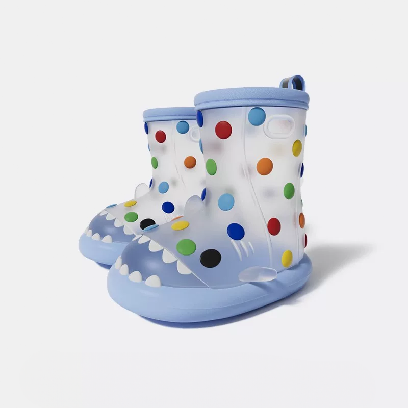 Blue rainbow polka dot shark rain boots for boys and girls, transparent design with multicolored dots, shark mouth details, anti-slip outsole for safe play.