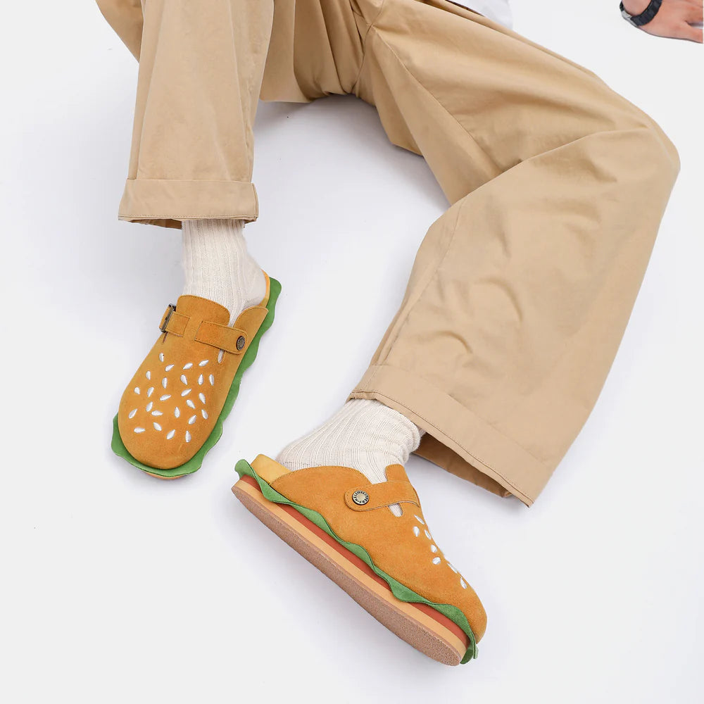 Close-up of a model sitting in burger-themed slippers, highlighting the sesame seed details and layered sole, designed for the same comfort as popular shark slippers.