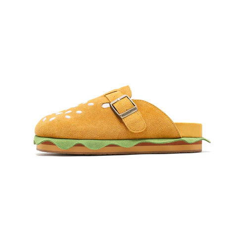 A profile shot of the burger slipper highlighting the green lettuce layer and the brown layered midsole resembling a hamburger patty.