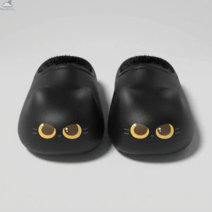 Front view of a pair of black Cloudsharks Friends cat paw slippers featuring cute cat ears, golden-yellow cat eyes, and a plush black fleece lining on a clean light grey studio background.