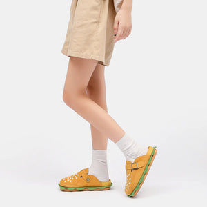 A model wearing tan shorts and white socks showcasing the side profile of the Burger Slippers from Cloudsharks Friends, a fun alternative to original shark slides.