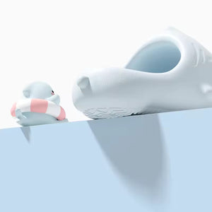 White Sharky Slides with a playful design, accompanied by a small character holding a life ring.