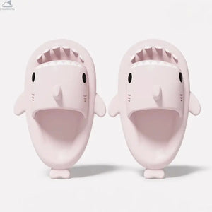 Overhead angle of soft ice pink shark slippers with open mouth detail and cushioned footbed.