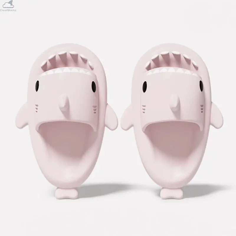 Overhead angle of soft ice pink shark slippers with open mouth detail and cushioned footbed.