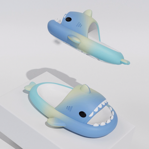 Two blue and green gradient shark slides, one floating and one on a white block, showcasing their vibrant ombre colors and playful shark design. Highlights smooth, flexible EVA texture.

