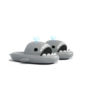 Stylish grey Cloudsharks shark slides featuring glow-in-the-dark whale spouting fins and cartoon shark teeth.
