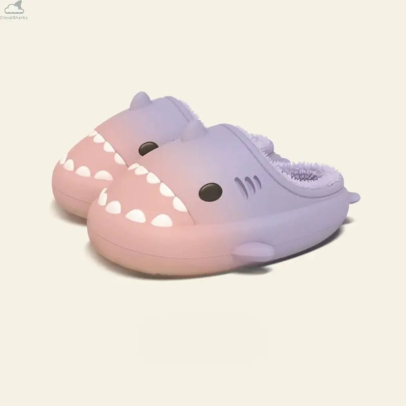 Pair of pastel pink and lavender gradient shark slides with cozy fleece lining, cloudsharks plush house slippers. A pair of Gradient Winter Shark Slides in a gentle pastel pink-to-lavender gradient with matching lavender fleece lining.