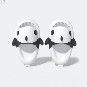 Top-down view of the pair of black and white Panda Shark Slides with a clean snout design, highlighting the inner footbeds, side fins, and shark teeth. Top-down view of white and black Cloudsharks Panda Shark Slides showing wide open-toe shark mouths with sharp teeth and comfortable cushioned footbeds.