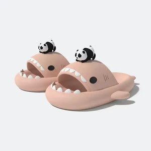 Pair of pink Panda Shark Slides with a black and white panda figure, found on cloudsharks.shop. The design is trendy and features the distinctive shark mouth and teeth.
