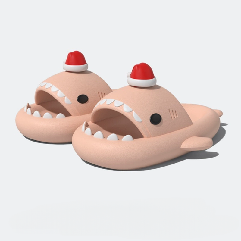 Pair of nude/beige/peach colored shark slides with white teeth and a red and white Santa hat, against a bright white background.