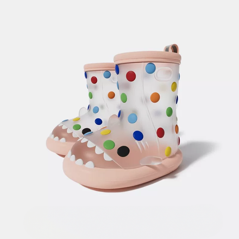 Matching pink rainbow polka dot shark rain boots pair, with colorful dots, shark teeth design, lightweight and flexible for active kids in rain or mud.