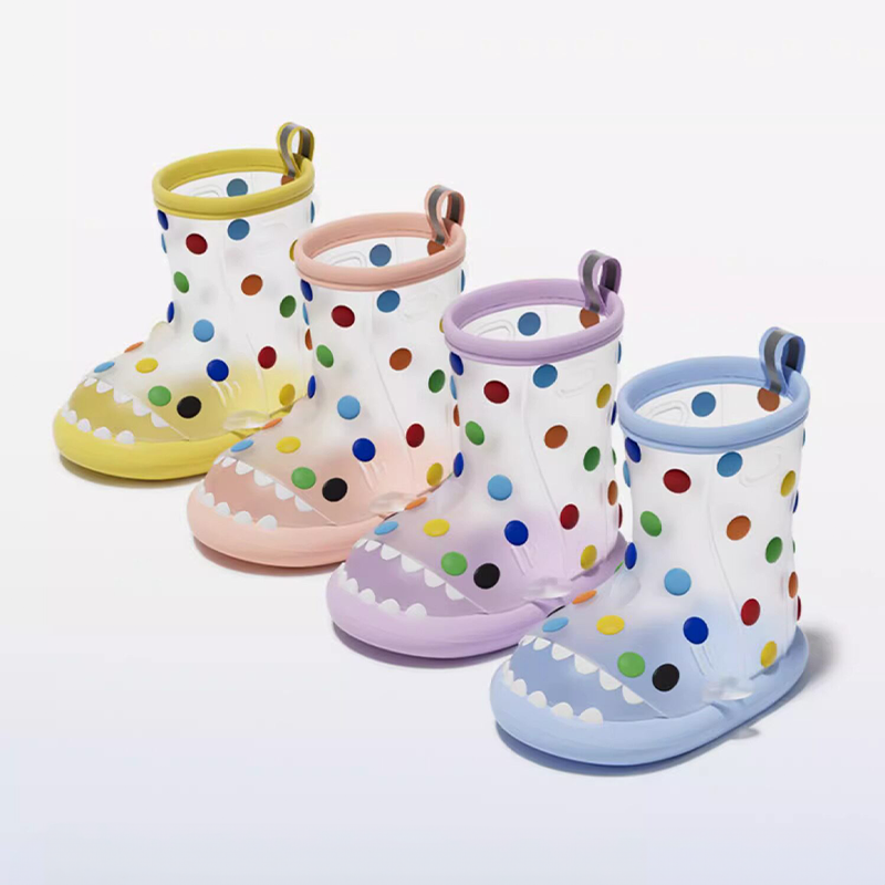 Four colorful variants of rainbow dot shark rain boots for toddlers: yellow, pink, purple, and blue, all with playful polka dots and cute shark design.