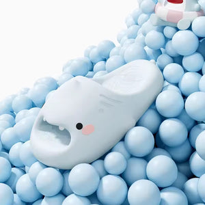 White Sharky Slides surrounded by soft blue balls, showcasing a playful shark face with fins.
