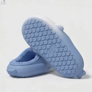 Bottom view of light blue gradient shark slippers displaying anti-slip deep grooved tread sole for indoor safety, non-slip shark slides.The bottom and side view of a light blue gradient shark slide, showcasing the deep-grooved, anti-slip treaded EVA sole.